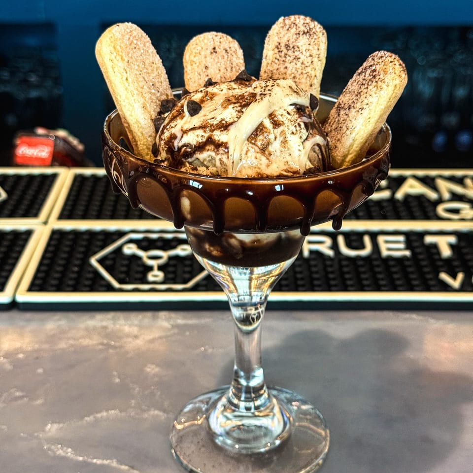 Chocolate sundae topped with whipped cream, chocolate sauce, and wafer cookies in a stemmed dessert glass.