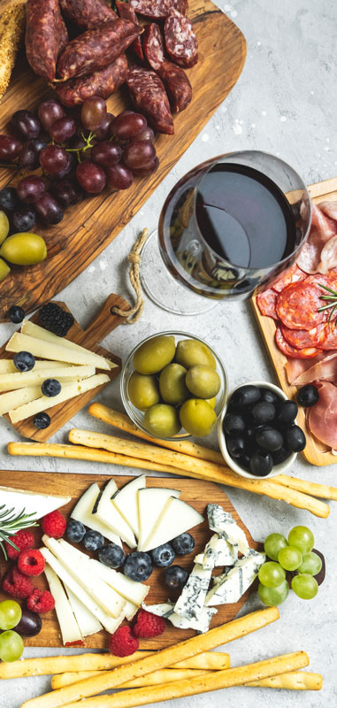 Charcuterie laid out on a table with glasses of wine.
